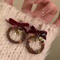Christmas wreath earrings with red velvet bow and gold bell worn on white sweater - Red Velvet Bow Wreath Bell Style (0459)