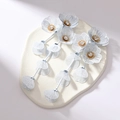 Dettaglio orecchini a fiore bianco opaco con petali in maglia metallica e lunghe nappe - Bianco