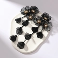 Detailed shot of long 3D black flower tassel earrings with crystals on stone base - Black