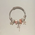 Detailed close-up of a silver charm bracelet with flower beads and forever star pendant - Pink Dancing Girl Bracelet