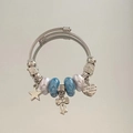 Macro shot of silver cable bracelet with heart 'love you' charm and blue beads - Blue Star Heart Bow Bracelet