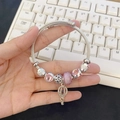 Silver beaded bracelet with pink crystal beads and lantern charm held over a keyboard - Pink Balloon Bracelet