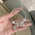 Silver charm bracelet with elephant and pumpkin carriage pendants on a woven chain - Big Ear Crown Bracelet