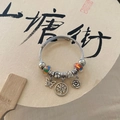 Silver beaded charm bracelet with butterfly and tree of life pendants on a fan - Colorful Butterfly Tree of Life Bracelet
