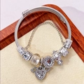Elegante zilveren bedelarmband met madeliefjes- en harthangers voor modieuze dames. - Engelenvleugels