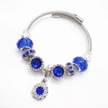 Zilverkleurige gedraaide kabelarmband met blauwe facetkralen en een zonnehanger - Blauwe Ster