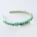Mint green headband with sparkling rhinestones and pearls on a geometric display - Light Green