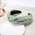 Detail of light green knitted headband with pearl embellishments and twist knot design - Light Green
