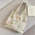 Dettaglio elegante borsa in raso con rose rosa su una superficie di tessuto morbido - Gilet Dipinto Ad Olio Primaverile
