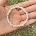 Close-up of white round faux pearl bracelet for girls on outdoor grass background - 5MM Cream White Pearl Bracelet