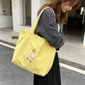 Detail van gele canvas shopper met schattig eendenborduurwerk en trekkoordsluiting - Geel