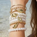 Set de pulseras playeras boho con estrellas de mar doradas y perlas blancas en modelo - Juego de 7 Pulseras de Perlas con Elementos Marinos Dorados (31271-bra-G-EP)