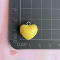 Detailed view of a 2cm bright yellow resin heart charm with a silver loop on a grid mat - Yellow Heart Pendant
