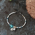 Bohemian seashell beaded bracelet with starfish charms and shells on stone surface - Sx564 Starfish Bracelet
