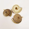 Detailed macro of three spiral shell pendants with gold plating and metal rings for DIY jewelry - Wheel Conch