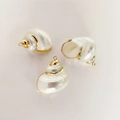 Macro shot of three natural conch shell pendants with elegant gold plated metal edges - Pearl Snail