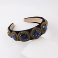 Close-up of a blue velvet headband featuring ornate sapphire crystals and gold rhinestones - Dark Blue