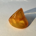 Macro shot of chunky amber resin ring showing translucent texture and geometric shadows - Orange(32355)