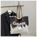 Détail du sac cabas en toile avec bords effilochés, imprimé Summer et anses en cuir - Noir