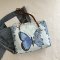 Hellblaue Canvas-Tragetasche mit Schmetterlingsdruck und weißen Fransen für den Sommer - Blau