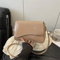 Bolso bandolera retro de charol marrón claro con correa ajustable en una cafetería - Caqui