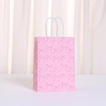 Elegante roze papieren cadeautas met donkerroze strikpatronen en witte handvatten - Grote Strik Kruisster (499-4) / 21*15*8