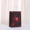Detail of Halloween paper gift bag with red spider web design and twisted white handles - Black Red Spider Pattern (497-2) / 21x15x11cm