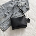 Minimalist black pebble leather bucket bag with adjustable strap and side charm - Black