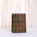 Juneteenth holiday gift bag with Pan-African stripes and star on black kraft paper - Black Ground Fist Pattern Style (498-2)