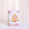 Close-up of paper gift bag with golden pumpkin carriage print and white rope handles - Pumpkin Carriage Pattern (492-6)