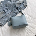 Light blue lychee leather bucket bag with adjustable strap and heart pendant detail - Blue