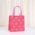 Pink non-woven gift bag with white bow print and handles for birthday shopping - All-over White Bow Print Pink Base Style (9038-1)