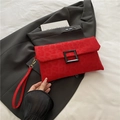 Red leopard print envelope clutch bag with black buckle and wrist strap on grey suit jacket - Red
