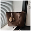 Dettaglio borsa tote marrone scuro sul davanzale con luce soffusa e ciondolo a stella soft - Con Ciondolo / caffè