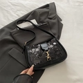 Borsa baguette nera con paillette e fibbia dorata su una giacca grigia elegante - Nero