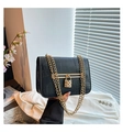Detalle de bolso de cuero de cocodrilo con cierre de corazón dorado y asa de cadena - Negro