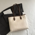 Minimalist beige leather tote bag with brown trim shown on a grey blazer - No Pendant / White