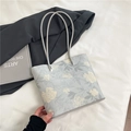 Hellblaue Shopper-Tasche mit Blumenmuster und schmalen Riemen im schlichten Look - Blau