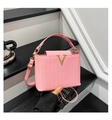 Detailed view of pink woven texture handbag with golden V-logo and long shoulder strap - Pink