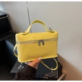 Primer plano de un bolso cuadrado de cuero amarillo veteado con doble cremallera plata - Amarillo