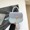 Bolso bandolera azul claro con solapa de tejido y hebilla dorada en fondo blanco limpio - Azul