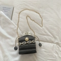 Detail of grey straw bucket bag featuring a white chunky chain and pearl decoration - Black