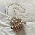 Detail of straw bucket bag with pearl accent, gold chain strap, and drawstring closure - Khaki