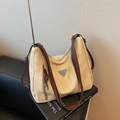 Bolso tote grande de ante beige con correas marrones sobre fondo de libro de arte - Blanco Roto