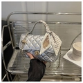 Detalle de bolso plateado acolchado con cierre dorado y asa decorada con pañuelo de seda - Plateado