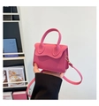 Nahaufnahme einer rosaroten Mini-Umhängetasche aus genarbtem Leder in der Hand - Rosa