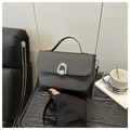Close-up of minimalist crossbody bag with grey woven texture and silver horseshoe buckle - Black