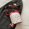 Borsa a secchiello bianca con stampa ciliegie e tracolla geometrica colorata su blazer grigio - Rosso