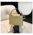 Dettaglio borsa champagne dorata con trama intrecciata e fibbia metallica a V elegante - Oro