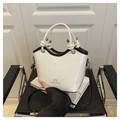 Gros plan du sac seau montrant la texture du cuir crème et la poignée en corde - Blanc